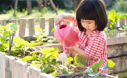 Image: Adobe A young girl watering plants